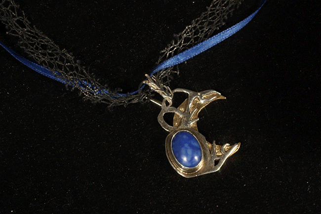 A moon-shaped neckless with a blue stone